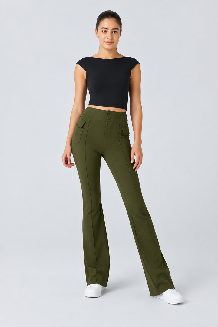 Woman wearing a black top and green pants on a light gray background