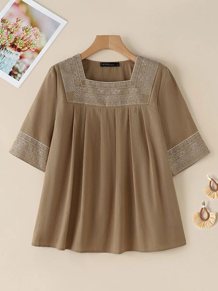Voel elke dag moeiteloze elegantie in onze blouse met vierkante hals en borduursel